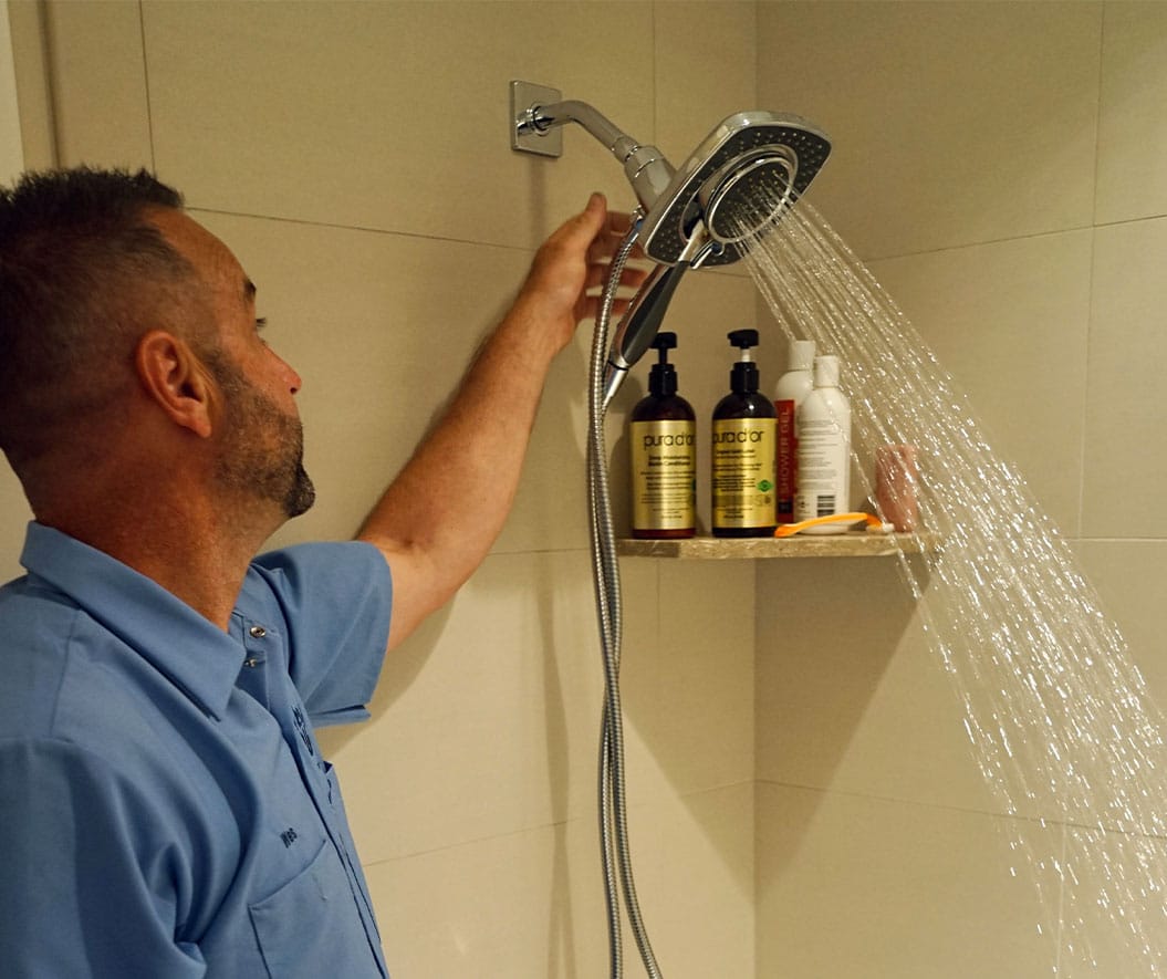 Service man checking shower faucet- plumbing issues Salt Lake City